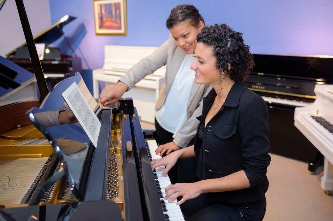 music teacher and a student looking at the music notes during the lesson